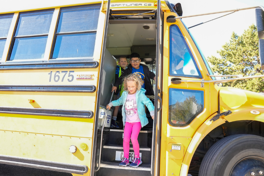 Little girl jumping off the steps of a bus - excited for her day at the Herrett Center