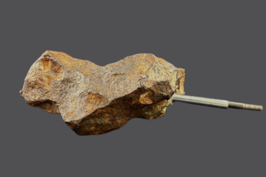 Image of a meteorite with a piece of metal attached for display