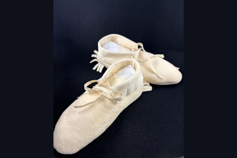 Image of white moccasins over a black background