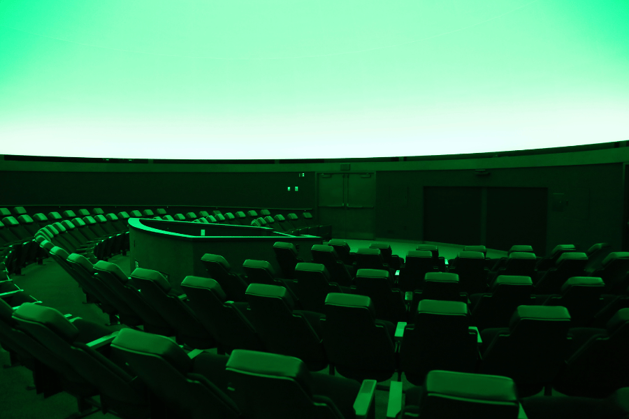 Imaage of the planetarium seating under a green light