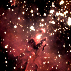 A close up image a nebula with a red hue